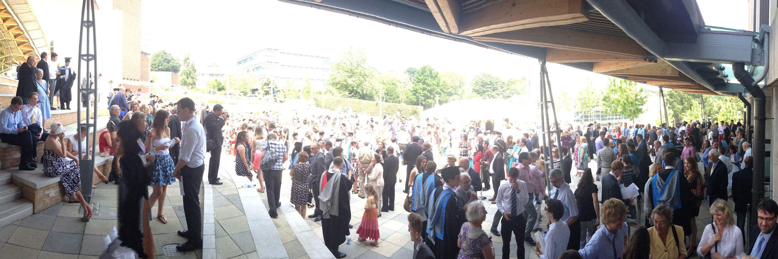 large crowd of students and families gather outside university on graduation day